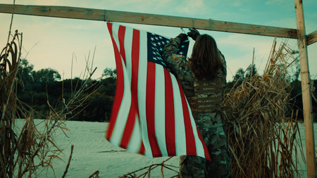 American flag waving on a beach during Memorial Day with a sailor soldierの写真素材
