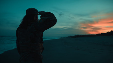 American soldier silhouette salutes in honor of Memorial Day on the beach