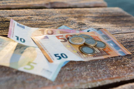 Euro Bills and Coins - Cash, Money Sunny Day on the Wood in a Warm Sunset Light
