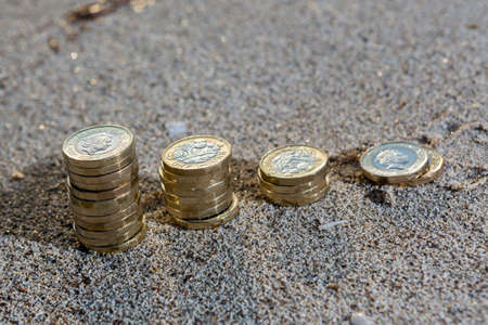 Picture of four piles  British pound coins. UK Money, New Pounds in a Warm Light. の写真素材