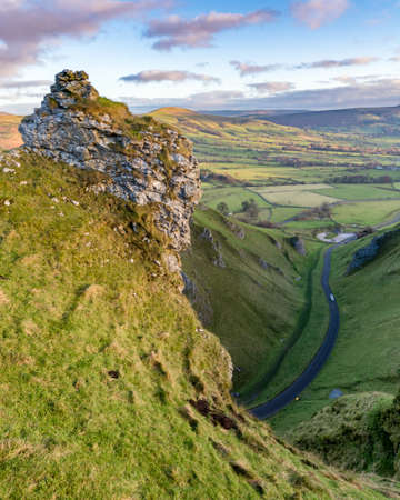 Mountain pass road leading through rural British countryside on a sunny late Autumn morning.の写真素材