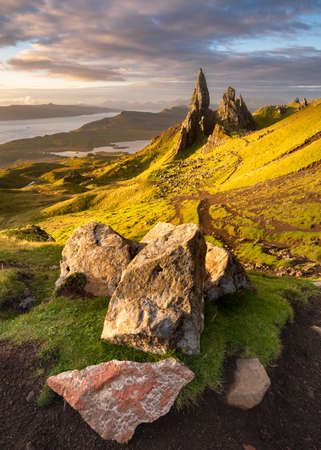 Breathtaking view of popular Scottish travel destination; The Old Man of Storr on the Isle of Skye. Dramatic clouds cover the morning sky with vibrant colours from the sunrise in the foreground.の写真素材