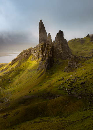 Dramatic view of The Old Man of Storr with low lying lingering clouds. Famous popular tourist destination on the Isle of Skye, Scotland, UK.の写真素材