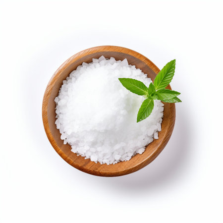 Sea salt in wooden bowl isolated on white background. Top view.の素材