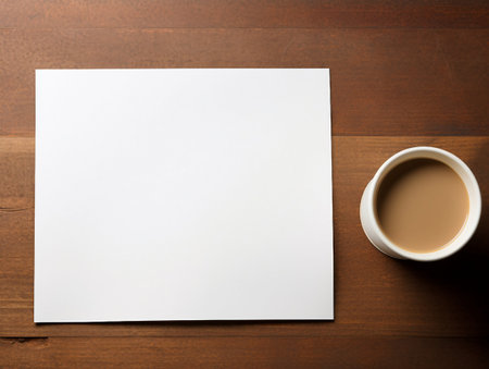 Blank paper and cup of coffee on wooden table. Mockup for designの素材
