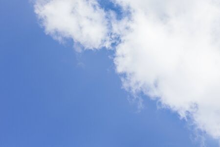 Blue sky with some clouds drawing a diagonal lineの写真素材