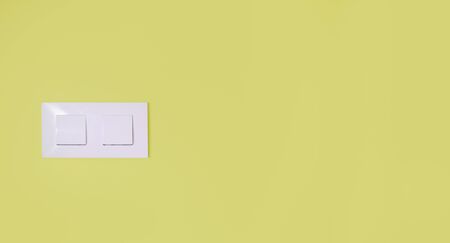 Light switch on a yellow wall with copy spaceの写真素材