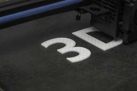 3D printer prints the word 3D with white filament PLAの写真素材