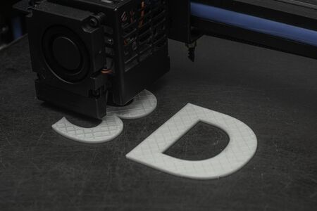 3D printer prints the word 3D with white filament PLAの写真素材