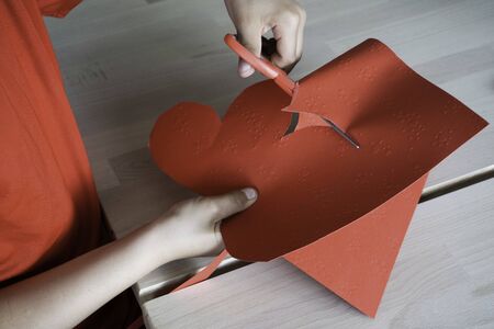 little man cuts out a heart - present for the mother and fatherの写真素材