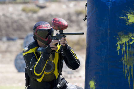 Paintball player shooting in the fieldの写真素材