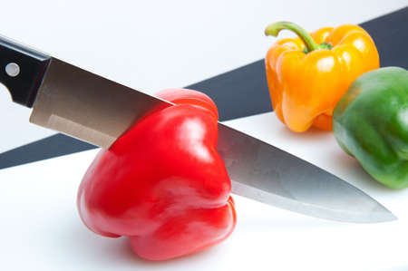A red pepper chopped on a table to cut with a knife の写真素材
