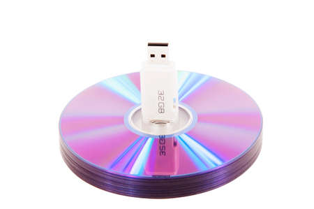 A stack of DVDs with an 32-gigabyte flash drive on white backgroundの写真素材