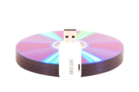 A stack of DVDs with an 32-gigabyte flash drive on white backgroundの写真素材