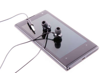 Black smartphone with headphones on white backgroundの写真素材