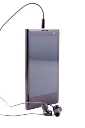 Black smartphone with headphones on white backgroundの写真素材