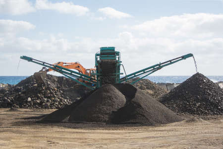 Excavator with a conveyor belt in a quarryの写真素材