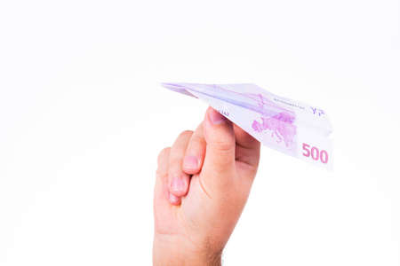 A hand holding a paper plane made with a 500 euro note on white backgroundの写真素材