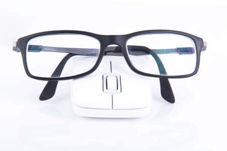 Black glasses on a white mouse on a gray table