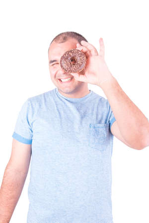 Happy man looking through the hole of a chocolate donut on white backgroundの写真素材