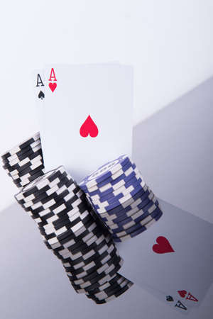 Pair of aces with a stack of chips on black reflective table