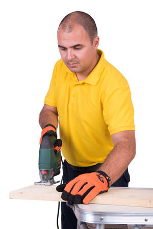 Carpenter cutting wood with a jigsaw isolated on white backgroundの写真素材