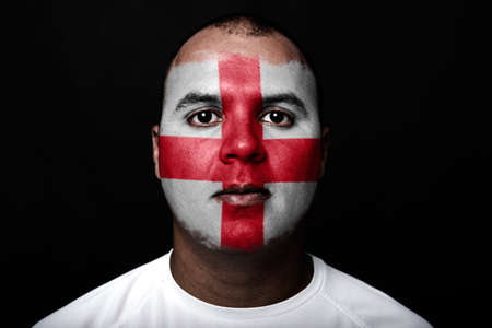 Man with England flag painted on her face on black backgroundの写真素材