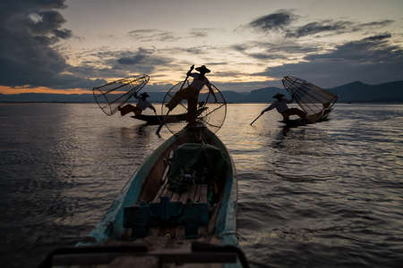 Intha fisherman posing with conical nets at sunset, Inle Lake in the Nyaungshwe Township part of Shan Hills in Myanmar Burmaの写真素材