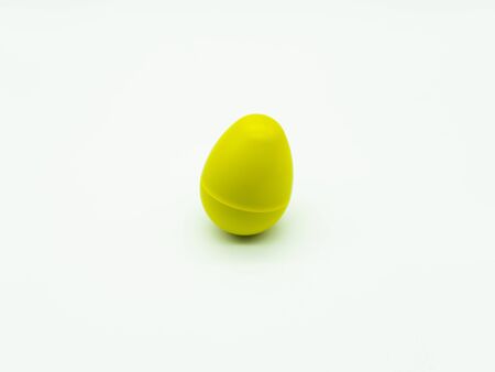 Top view of yellow egg shaker on a white background. Percussion instrument concept.の写真素材