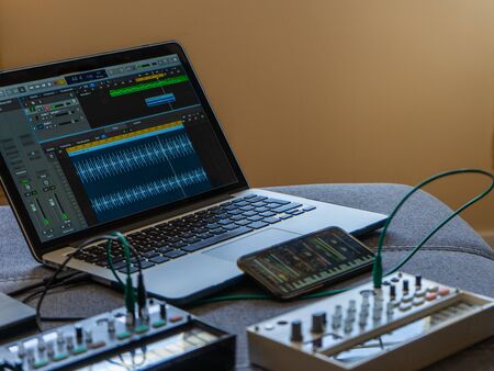 Close up view of fm synthesizer, sampler, smartphone with modular synthesizer and laptop with a DAW. Electronic music concept.の写真素材