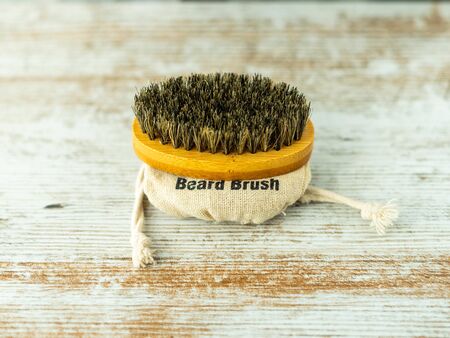 Beard brush with natural bristles made of bamboo insulated on a wooden base. Facial care concept.の写真素材