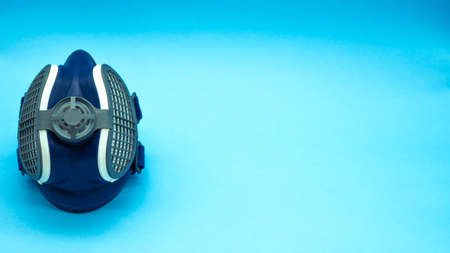 Top view of isolated coronavirus mask on a blue background, located on the left of the image with space for text on the right. Concept virus. Covid-19.の写真素材