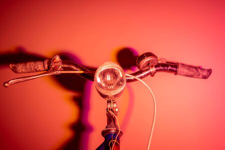 Handlebar with headlight from an old bike with colored shades. Vintage concept. Neon lights.