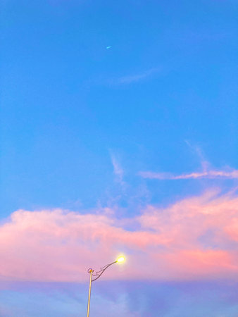 Sunset sky with clouds and street lamp. Beautiful natural background.
