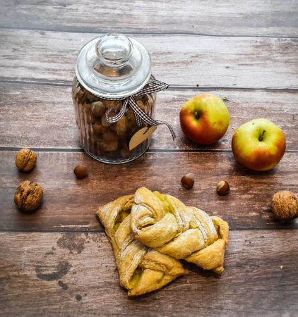 Pie with apples and hazelnuts on a wooden backgroundの写真素材