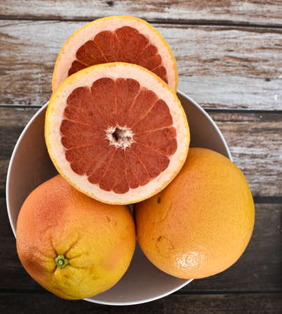 Grapefruits in bowl, tasty juicy fruitの写真素材