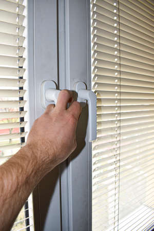 Person is opening window in living roomの写真素材