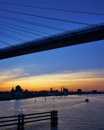 Bridge to the island of Ruegen with sunset and sailboat. germany