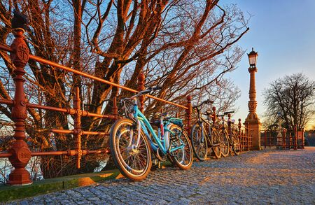 Bicycles on a bridge lit by the setting sun.