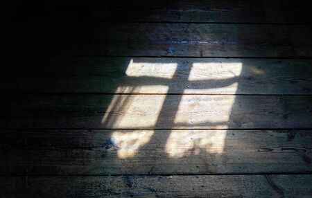 Light shines through a window on the wooden background.の写真素材