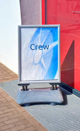 Sign with the word Crew in front of the entrance to an airport or cruise ship port.