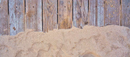 Beach sand on wooden planks. Summer background with copy space as top view.の写真素材