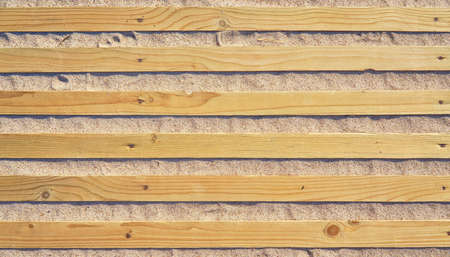 Path made of wooden boards on the sandy beach as a travel background.