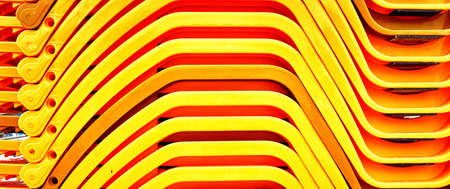 Stacked red yellow beach loungers by the sea as a vacation background.の写真素材