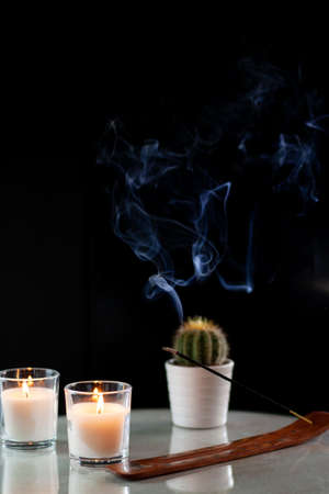 composition for relaxation, candles, incense and cactus on black background with fumeの写真素材
