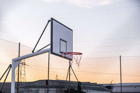 Basketball court in industrial estate at sunset
