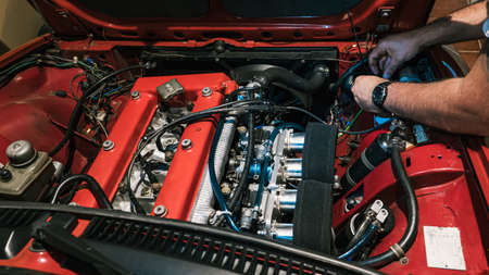 mechanic hands fixing a vintage red car