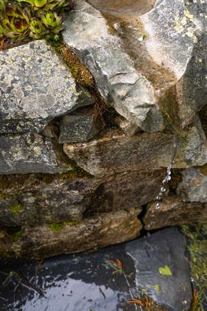 natural source of cold and pure spring water between stones and slate
