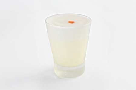 Pisco sour, a typical Peruvian drink based on Pisco and lemon on a white backgroundの写真素材