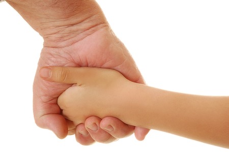 a parent holds the hand of a small child. On a white background.の写真素材